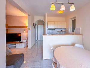 a kitchen and a living room with a table and a couch at Studio Vesna with a terrace and sea view in Rabac +20 photos