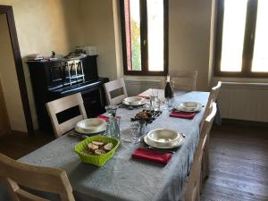 a dining table with a blue table cloth and plates and glasses at La maison de Laujol in Moissac +25 photos