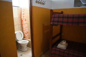 a small bathroom with a toilet and a bunk bed at Caroline lodging in Huaraz