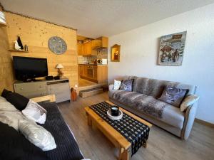 a living room with a couch and a coffee table at Isola 2000 centre galerie 6 couchage 35m2 aux pieds des pistes in Isola 2000