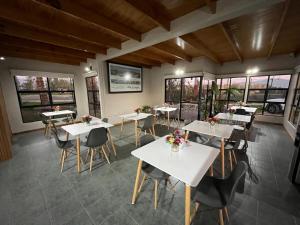 a restaurant with white tables and chairs and windows at Hotel Altos de Tuqui in Ovalle