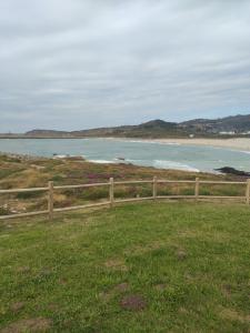a wooden fence in front of a beach at Fonte da Horta in Arteixo