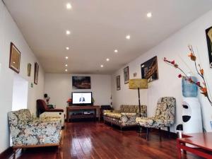 a living room with two chairs and a tv at Hotel El Cid Plaza Premium in Tunja