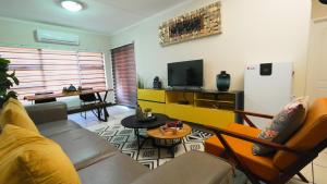 a living room with a couch and a tv at Earthy and Organic in Johannesburg