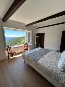 a bedroom with a bed and a large window at Sublime maison de montagne in Guillaumes