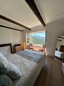 a bedroom with a bed and a large window at Sublime maison de montagne in Guillaumes