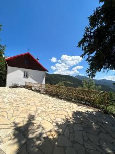 a building with a red roof and a stone patio at Sublime maison de montagne in Guillaumes