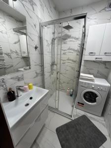 a bathroom with a shower and a washing machine at Mieszkanie w Centrum in Białystok +8 photos