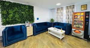 ein Wohnzimmer mit blauen Sofas und einer grünen Wand in der Unterkunft Stef Rooms in Tîrgu Frumos
