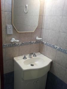 y baño con lavabo blanco y espejo. en Apartamento Miramar II en Miramar
