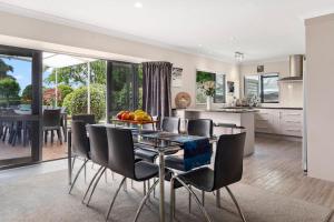 a kitchen and dining room with a table and chairs at Tropical Avocado Orchard Escape Ohauiti in Ohauiti