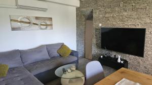 a living room with a couch and a flat screen tv at Vila Emona in Mali Lošinj