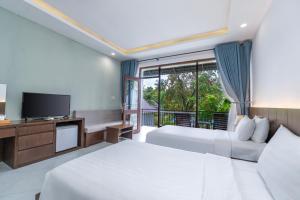 a hotel room with two beds and a television at Kingo Retreat Resort in Phu Quoc +124 photos