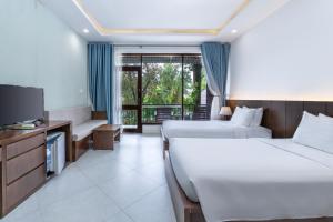 a hotel room with two beds and a television at Kingo Retreat Resort in Phu Quoc