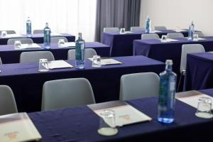 Una habitación con mesas azules y sillas con botellas. en Hotel Santiago Apóstol, en Santiago de Compostela