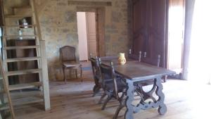 une salle à manger avec une table en bois et une échelle dans l'établissement Gîtes dans village médiéval Périgord, à Limeuil