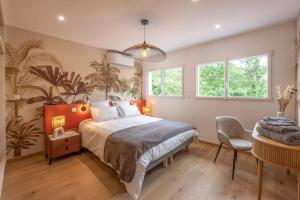 a bedroom with a large bed and a chair at Superbe maison sur pilotis in Savy-Berlette