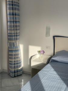 a bedroom with a bed and a vase of flowers on a table at La Tranquilla Apartment in Capri