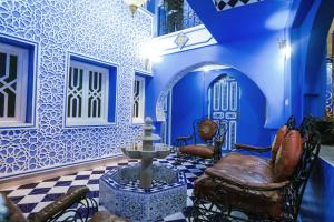 a living room with blue walls and a fountain at RIAD CHENGLI 蓝城里 in Chefchaouen