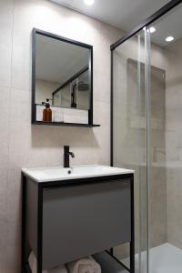 a bathroom with a sink and a mirror at BUBU Apartments By Charming Stay in Málaga