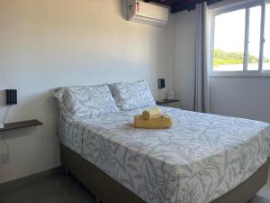 a bedroom with a bed with a yellow stuffed animal on it at TRANQUILA FLATS in Morro de São Paulo +33 photos