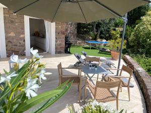 a patio with tables and chairs under an umbrella at villa Podaroc in Fréjus
