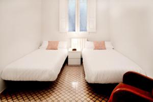 a room with two beds and a window at Casa Valeta in Barcelona