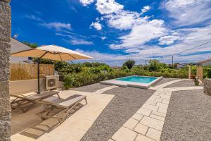 a patio with a table and an umbrella and a pool at Holiday house Rural home Frane in Kornić