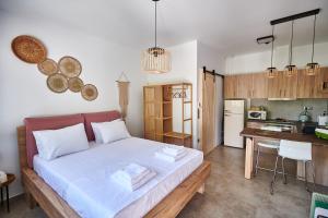 a bedroom with a large bed and a kitchen at The lemon house in Artemida