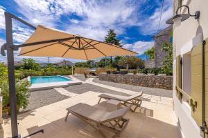a patio with a table and an umbrella at Holiday house Rural home Frane in Kornić