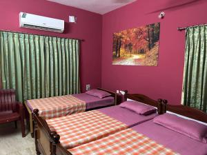 two beds in a room with purple walls at Chidambaram Spiritual Stay in Chidambaram