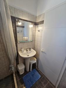 a bathroom with a sink and a mirror and a shower at Natura Studios in Andipáta Erísou +33 photos