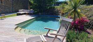 a chair sitting next to a small swimming pool at Clos Baroanni - Chambre Oléa in Terraube