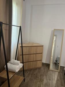 ein Badezimmer mit Kommode und Spiegel in der Unterkunft Ammos & Thalassa Apartments in Ofrynio