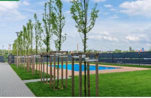 a swimming pool with trees in a park at Aparts Care Beztroski Apartament Ku Morzu in Sianozety