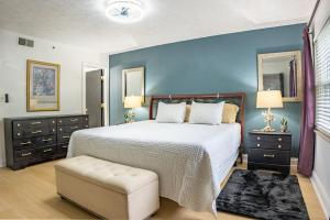 a bedroom with a large bed and a blue wall at Cozy Smoky Mtn 2br Getaway W Pool Fireplace in Gatlinburg +68 photos