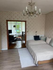 Un dormitorio con una cama grande y una lámpara de araña. en Jokai Park Nyaralo, en Siófok 3 fotos más