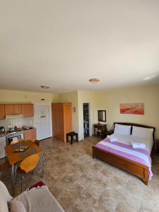 a bedroom with a large bed and a kitchen at Natura Studios in Andipáta Erísou