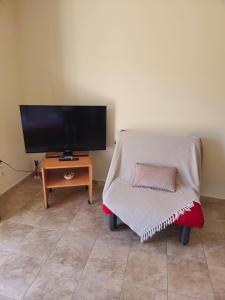 a living room with a tv and a chair at Natura Studios in Andipáta Erísou