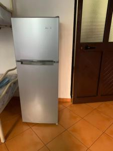 a white refrigerator in a room with a door at Mani rooms in Durrës