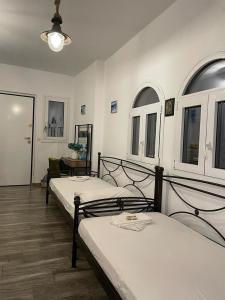 a room with three beds and a table at Lagonisi MAGIC HOME RELAXATION in Kalívia Thorikoú
