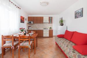 a living room with a red couch and a table at Villa Lidija in Labin