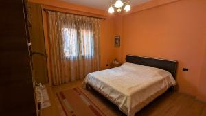a bedroom with a bed and a window at visitShkoder - Noel's Home in Shkodër