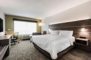 a hotel room with a large bed and a window at Holiday Inn Express & Suites - Welland in Welland