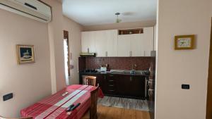 a small kitchen with a table and a sink at visitShkoder - Noel's Home in Shkodër