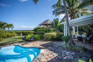 リヴィエール・ノワールにあるMaison 2 chambres avec vue et piscine privéeのリゾートプール(椅子、ガゼボ付)