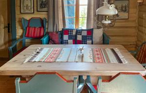 einen Holztisch in einem Zimmer mit Stühlen und einem Tisch sidx sidx sidx in der Unterkunft Three-Bedroom Holiday Home In Sjusjoen in Sjusjøen