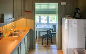 eine Küche mit einer Spüle und einem Tisch mit einem Stuhl in der Unterkunft Three-Bedroom Holiday Home In Sjusjoen in Sjusjøen