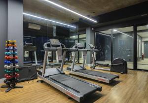 a gym with three tread machines and a mirror at Studio Style - Vila Olímpia in Sao Paulo