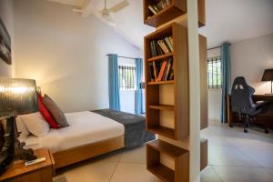 リヴィエール・ノワールにあるMaison 2 chambres avec vue et piscine privéeのベッドルーム(ベッド1台、本棚付) +90枚の写真